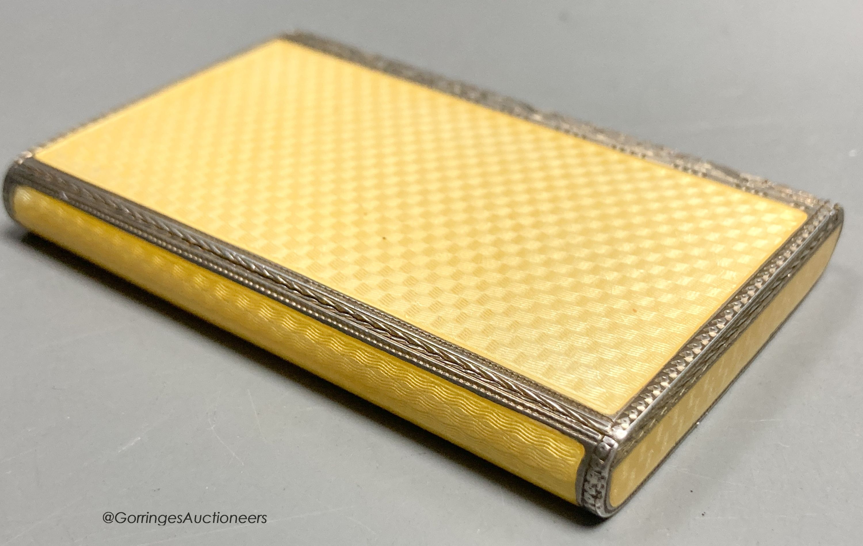 A 1920's continental silver and yellow guilloche enamel rectangular box and hinged cover, import marks for P.H. Vogel & Co, London, 1927, 79mm by 53mm by 10mm